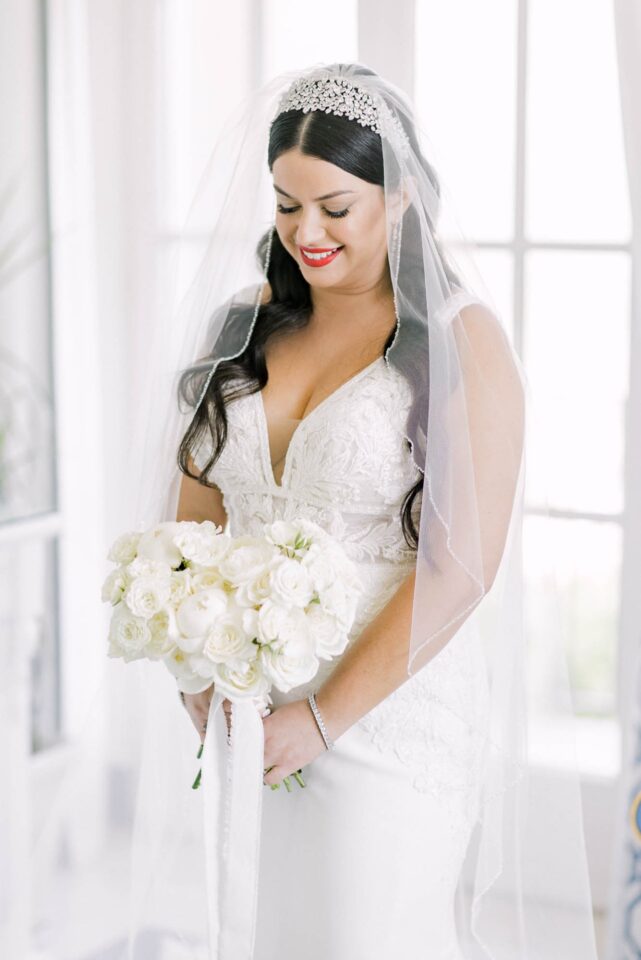 bride looking at her white bridal bouquet