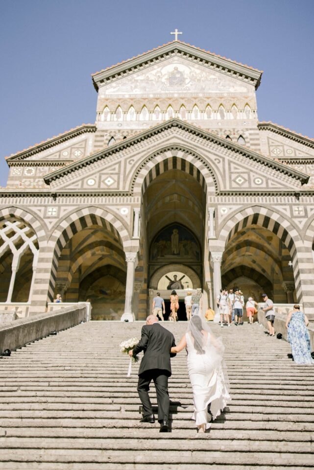 bride walking up with her father to the stairs on the Duomo in Amalfi